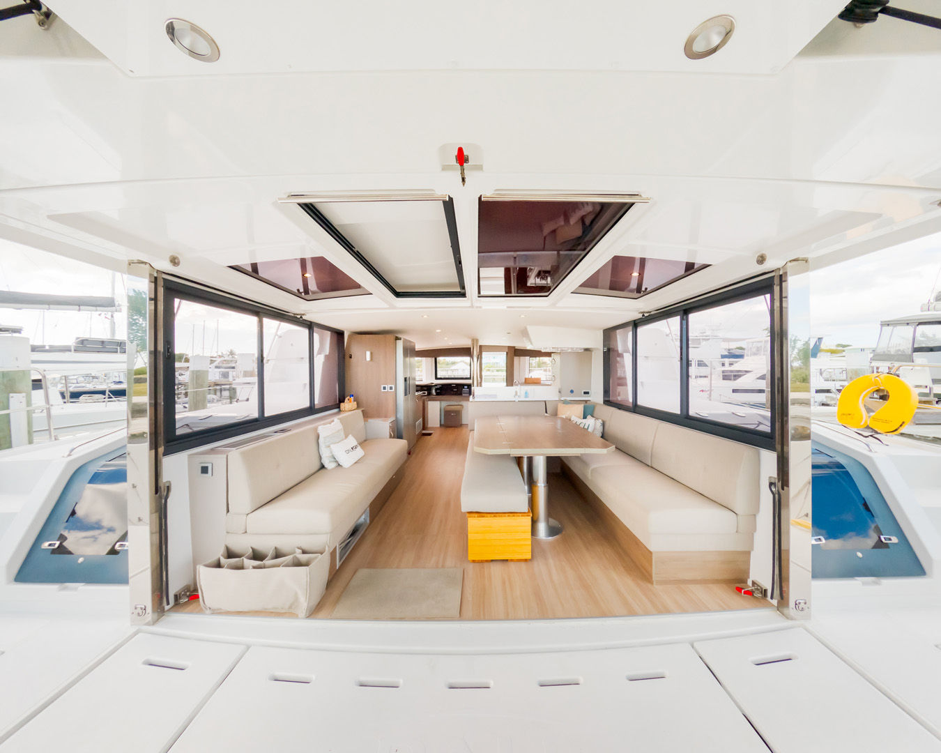 The interior of a boat featuring wooden benches, a steering wheel, and nautical decor.