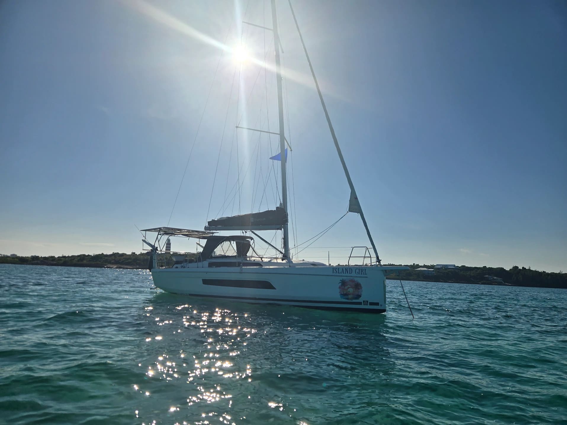Our Reviews 9 A boat rests on the beach beside another white boat, with sand and gentle waves in the background.